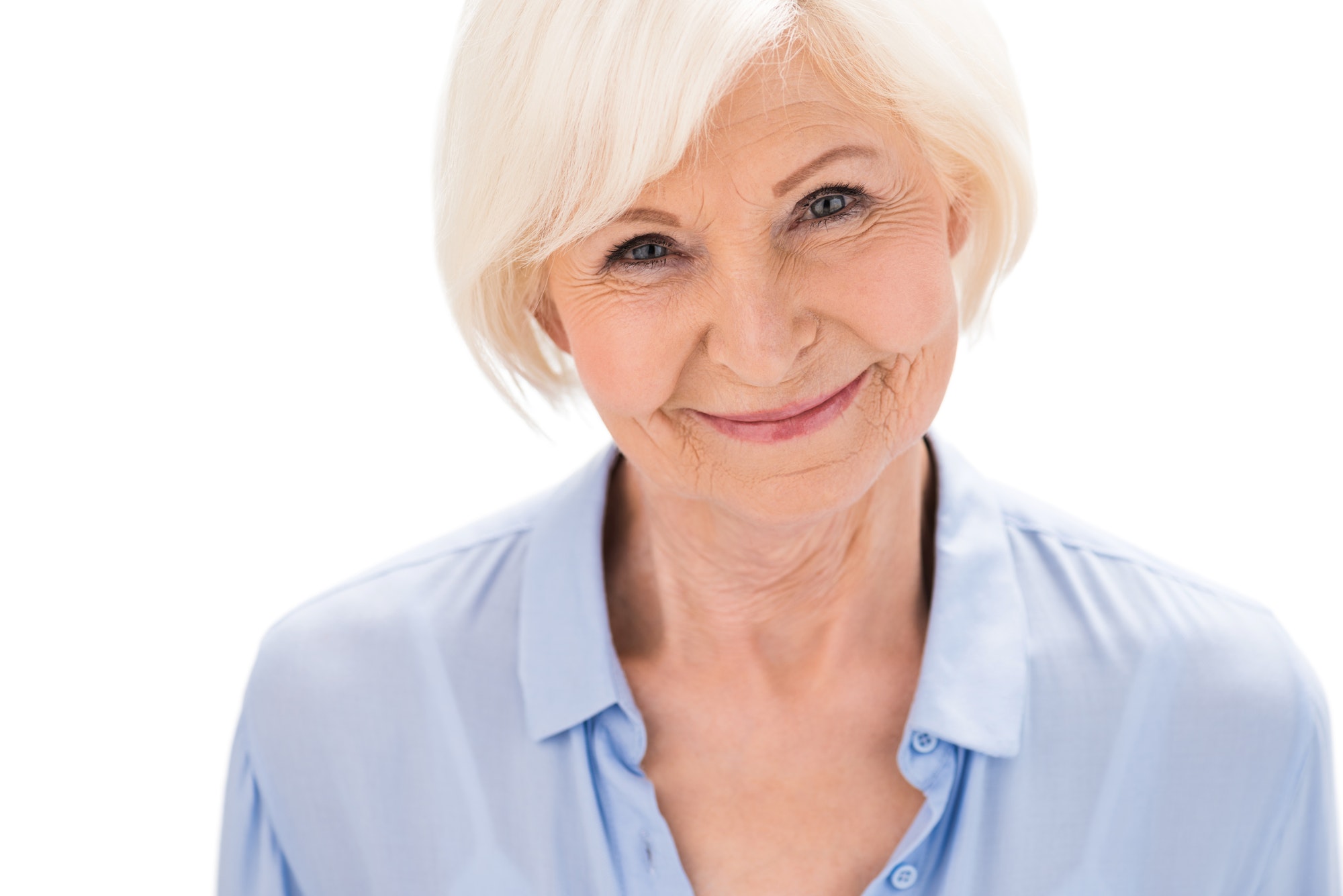 portrait of happy senior woman looking at camera isolated on white in studio